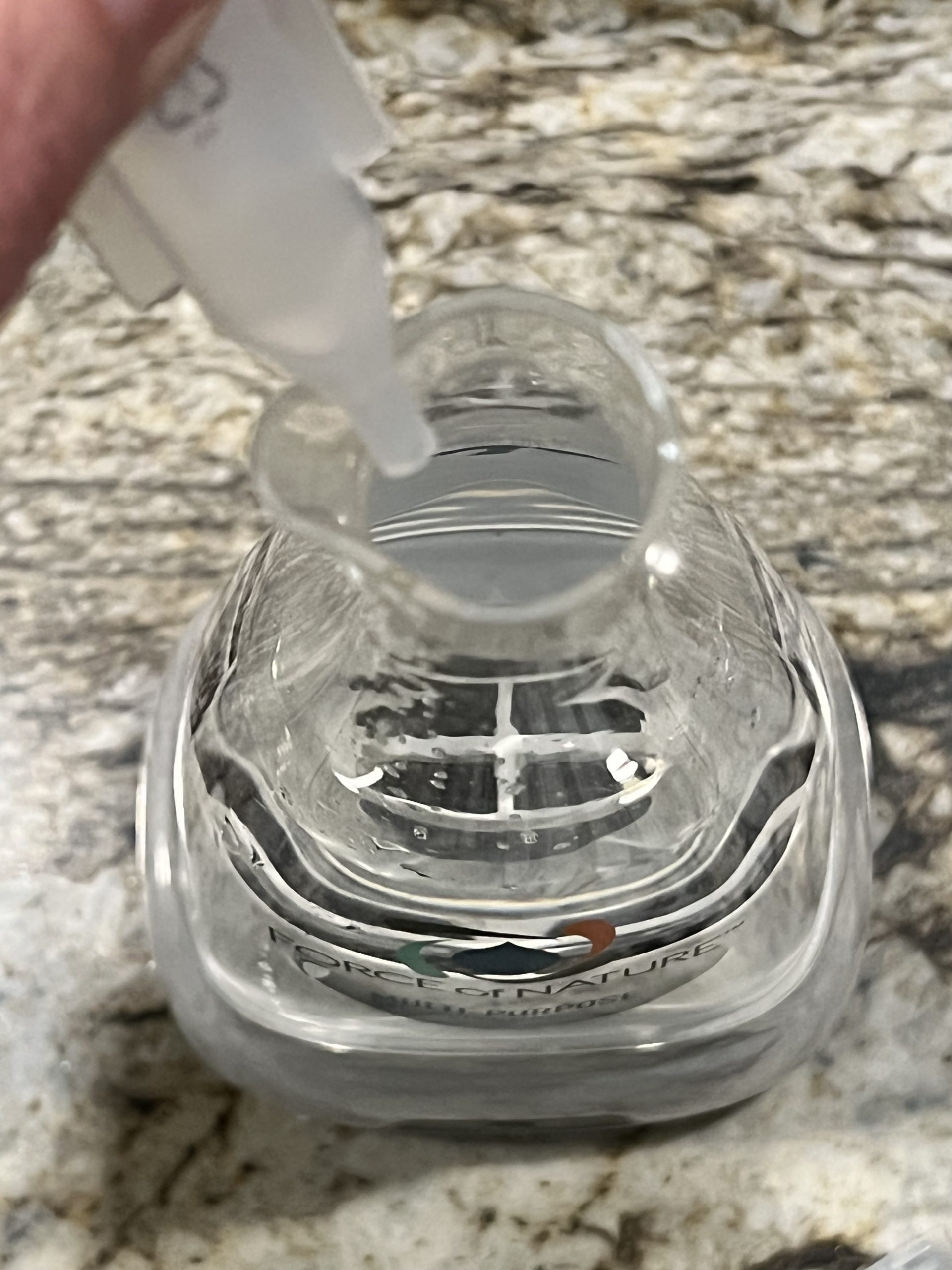 Adding the vinegar solution capsule to the Force of Nature container