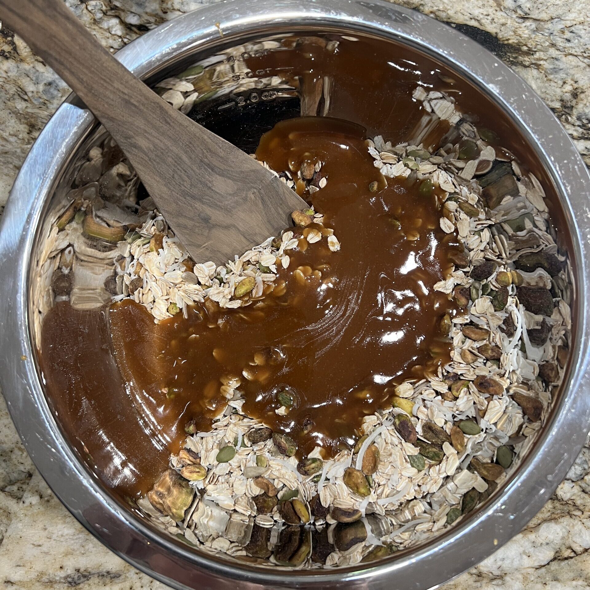 Mixing the liquid and dry ingredients together for the best damn healthy granola recipe.